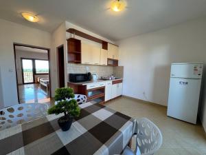 a kitchen with a table and a white refrigerator at Apartments Bernarda 2 in Nin