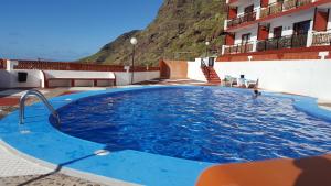 a large blue swimming pool in front of a building at Altamira in Bajamar