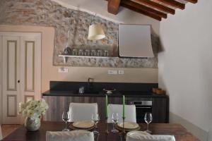 a dining room with a table with chairs and a kitchen at La Vecchia Scuola in Stifone +35 photos