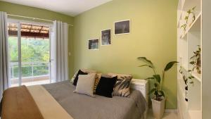 1 dormitorio con paredes verdes y 1 cama con almohadas en Casa beira Rio, en Sana