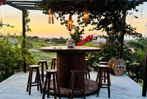 a bar with stools under a pergola at Chalés Sossego da Serra in Serra de São Bento