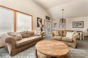 a living room with couches and a table at Good Sun-Sations in Corolla