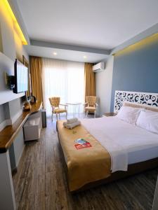 a hotel room with a large bed and a table at KUPALA BEACH HOTEL in Büyükkeçeli