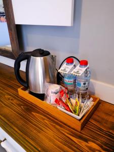 a wooden drawer with a tea pot and drinks on it at KUPALA BEACH HOTEL in Büyükkeçeli