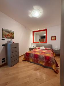 a bedroom with a bed and a dresser and a mirror at Appartamento Girasole in Tenna 