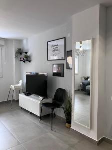 a living room with a desk with a chair and a mirror at Alojamientos centro in Yecla