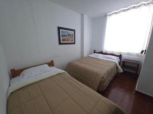 Dos camas en una habitación con ventana. en Hospedaje Grau, en Puerto Chicama 17 fotos más