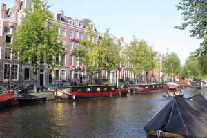 un grupo de barcos atracados en un canal con edificios en Luxury canal suite in the best location of Amsterdam !!!, en Ámsterdam