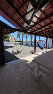 eine Terrasse mit Hängematte, Tisch und Schaukeln in der Unterkunft Casa das Palmeiras - 80 metros do mar in Navegantes + 25 Fotos