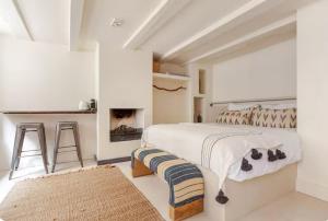 Un dormitorio blanco con una cama y una chimenea. en Luxury canal suite in the best location of Amsterdam !!!, en Ámsterdam