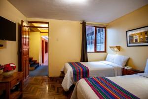a hotel room with two beds and a television at Eco Inn in Cusco +44 photos