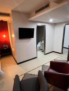 a living room with a flat screen tv on a wall at Hotel Leblanc Suites in Puerto La Cruz