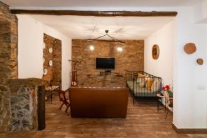 a living room with a brick wall and a tv at Casa da Courela do Olival - Santo Aleixo 