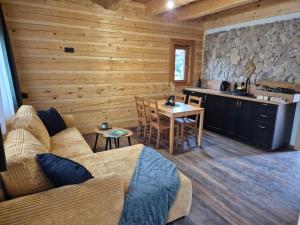 a living room with a couch and a table and a kitchen at tradičná Čičmanská drevenica in Čičmany