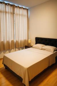 ein Schlafzimmer mit einem großen weißen Bett mit einer Lampe in der Unterkunft Moderno y hermoso apartamento en Tarapoto con 3 Dormitorios, ideal para familias in Tarapoto