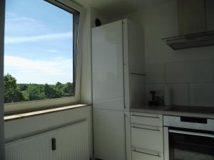 デュースブルクにあるModernes Apartment Duisburgのキッチン(白い冷蔵庫付)、窓