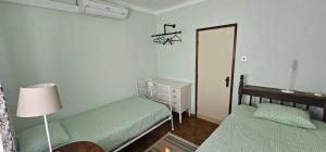 ein kleines Schlafzimmer mit 2 Betten und einer Tür in der Unterkunft Casa da Praia - Group Accommodation in Praia da Vitória