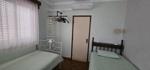 zwei Betten in einem Zimmer mit einer Tür und einem Fenster in der Unterkunft Casa da Praia - Group Accommodation in Praia da Vitória + 13 Fotos