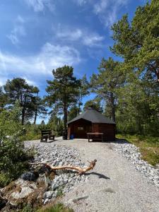 a cabin with a bench on a gravel road at Geiloholtet central city apartment in Geilo