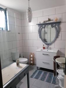 ein Badezimmer mit Waschbecken, Toilette und Spiegel in der Unterkunft Casa da Praia - Group Accommodation in Praia da Vitória