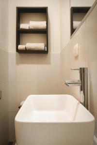 ein Badezimmer mit einem weißen Waschbecken und Handtüchern auf einem Regal in der Unterkunft Moderno y hermoso apartamento en Tarapoto con 3 Dormitorios, ideal para familias in Tarapoto