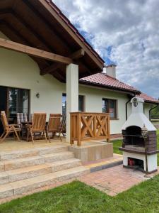 a patio with a fireplace and a house at Warmińskie Lokum in Woryty