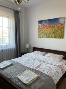 a bedroom with a bed with a painting on the wall at Warmińskie Lokum in Woryty