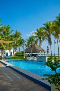 una piscina con palme e una spiaggia di Mangomar Beach House a Teotepeque