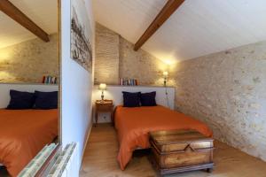 a bedroom with two beds in a room at La Roche des Bois, maison classée *** (8 pers) in Saint-Laurent-de-la-Prée