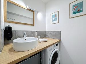 a bathroom with a sink and a washing machine at Joli T2 lumineux proche centre & piscine in Clermont-Ferrand