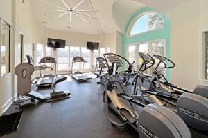 a gym with several cardio machines in a room with windows at Its All Good In Corolla in Corolla