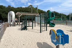 a playground with a slide in the sand at Its All Good In Corolla in Corolla