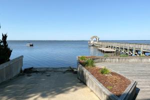 a dock on a lake with a boat in the water at Its All Good In Corolla in Corolla