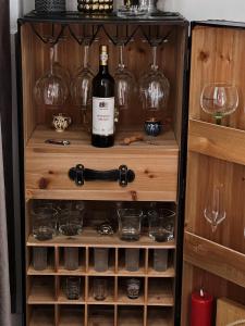 a wooden cabinet with a bottle of wine and glasses at Zara’s Home Apartaments in Petroşani +33 photos