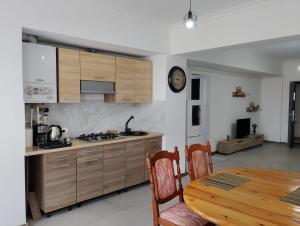 a kitchen with a table and a clock on the wall at Mary Studio in Bistriţa