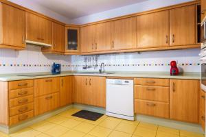 a kitchen with wooden cabinets and a white dishwasher at Living Sol - Centric Urban Room in Santa Cruz de Tenerife +43 photos