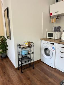 a laundry room with a washing machine and a microwave at Apartament tatarski PARKING! in Przemyśl