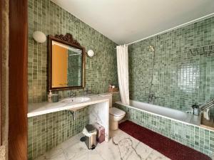 Un baño con lavabo, bañera e inodoro. en Casa do Bidueiro, en Luou