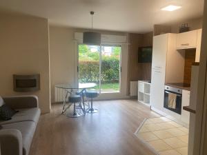 ein Wohnzimmer mit Tisch und Küche in der Unterkunft Rez de jardin centre Saint Arnoult in Deauville