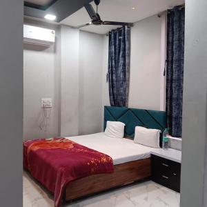 乌贾因Hotel Shiv palace的卧室里有一张床，床上铺着一条红毯子