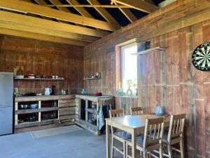 a kitchen with a table and chairs and a refrigerator at Glamping Rusne in Rusnė