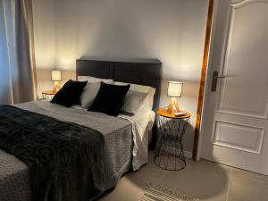 a bedroom with a bed and two lamps and a door at Refúgio do Nevoeiro Apart T1 in Porto Moniz