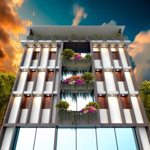 a tall white building with potted plants on it at Hotel Nagar in Khulna