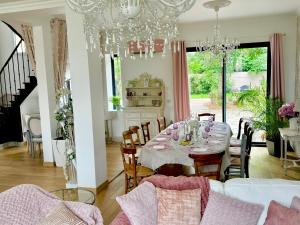 a dining room with a table and a chandelier at Château Ségot in Neuilly-le-Réal