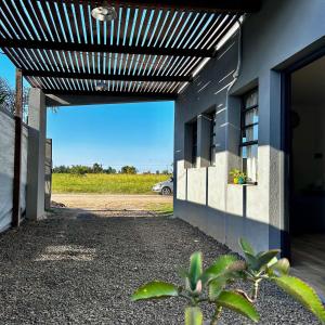a building with a pergola on the side of it at LIVe in Villa Elisa