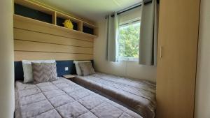 Un pat sau paturi într-o cameră la Mobil-home N 3 chambre, climatise, cuisine equipee, TV & Wi-Fi +26 fotografii