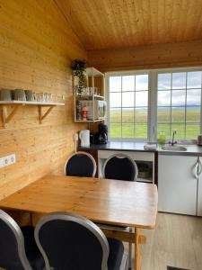 a kitchen with a wooden table and chairs at Guesthouse Stöng and Cottages in Stöng