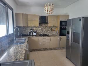 a kitchen with a stainless steel refrigerator and a sink at Villa blancha beach sidi rahal in Sidi Rahal