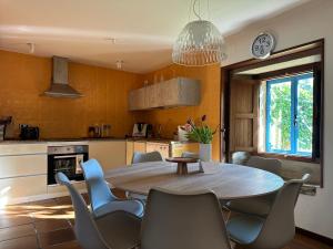 Una cocina con una mesa y sillas en una cocina. en Casa do Bidueiro, en Luou