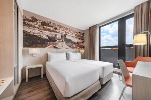 a hotel room with a white bed and a window at EXE Liberdade in Lisbon